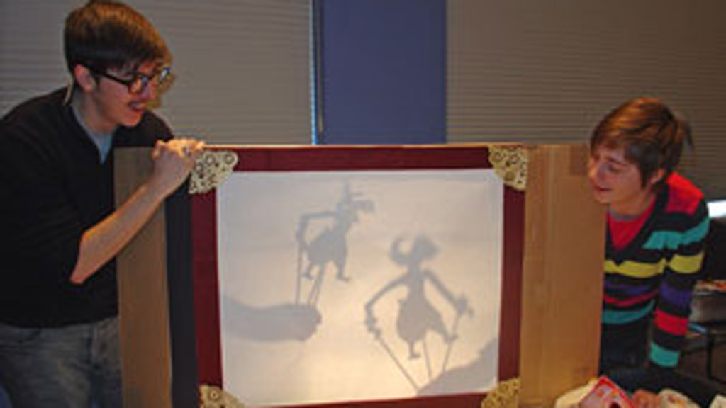 Two students test out a shadow puppet screen