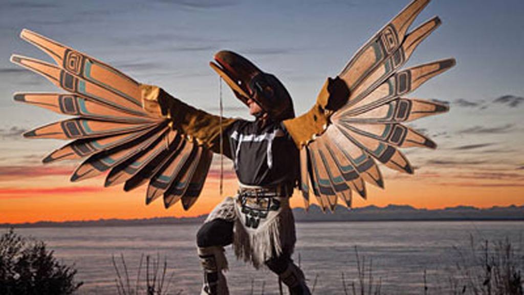 Photo of Gene Tagaban posing in a birdlike costume
