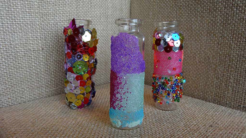 Three bottles filled with colorful microbeads