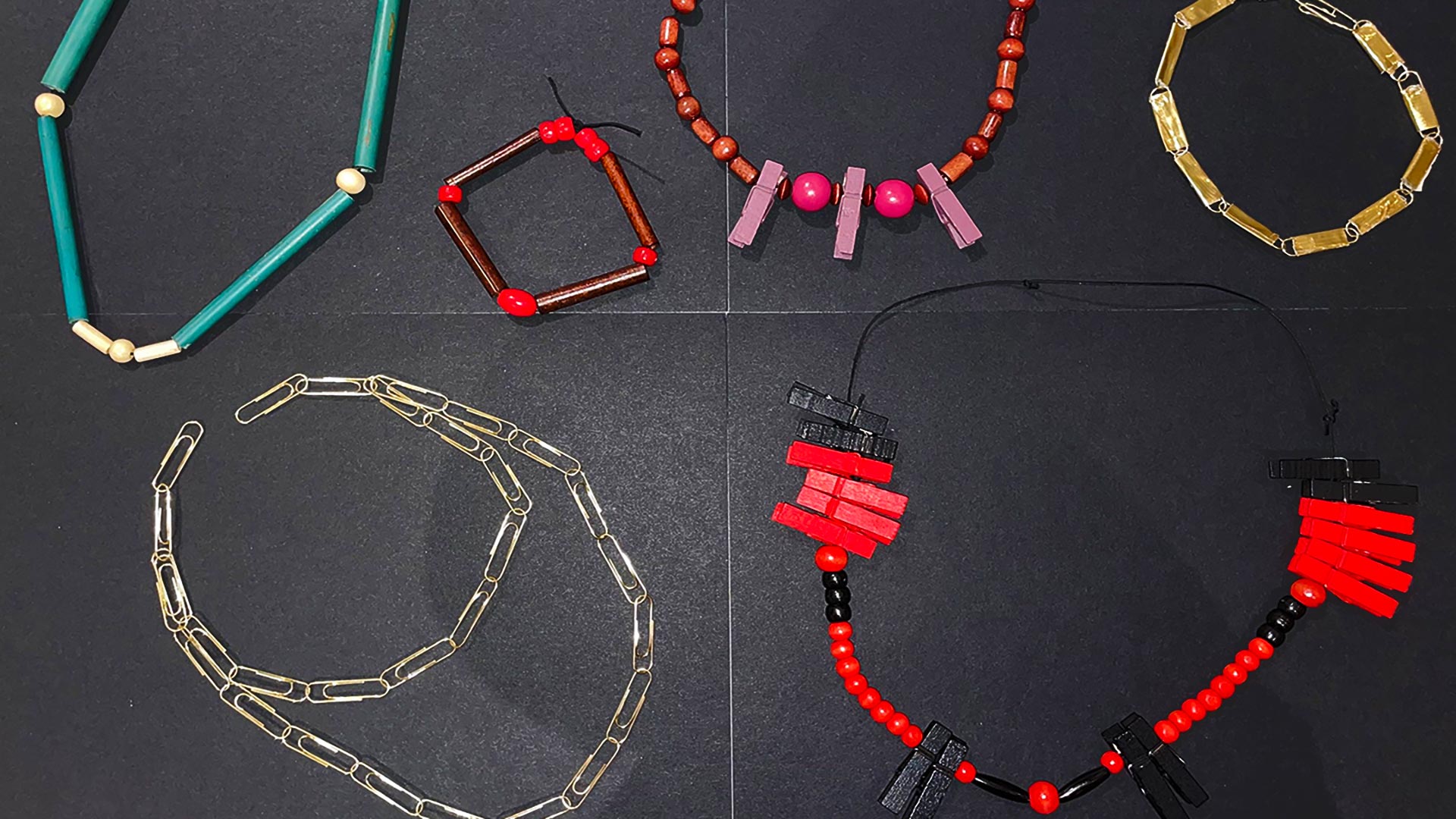 Six handmade necklaces made of multicolored paperclips, wooden beads, and clothespins